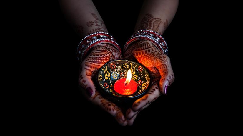 A woman holding diwali diya