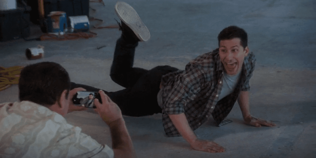 Jake Peralta posing for a picture while lying flat on the floor of Nakatomi Plaza